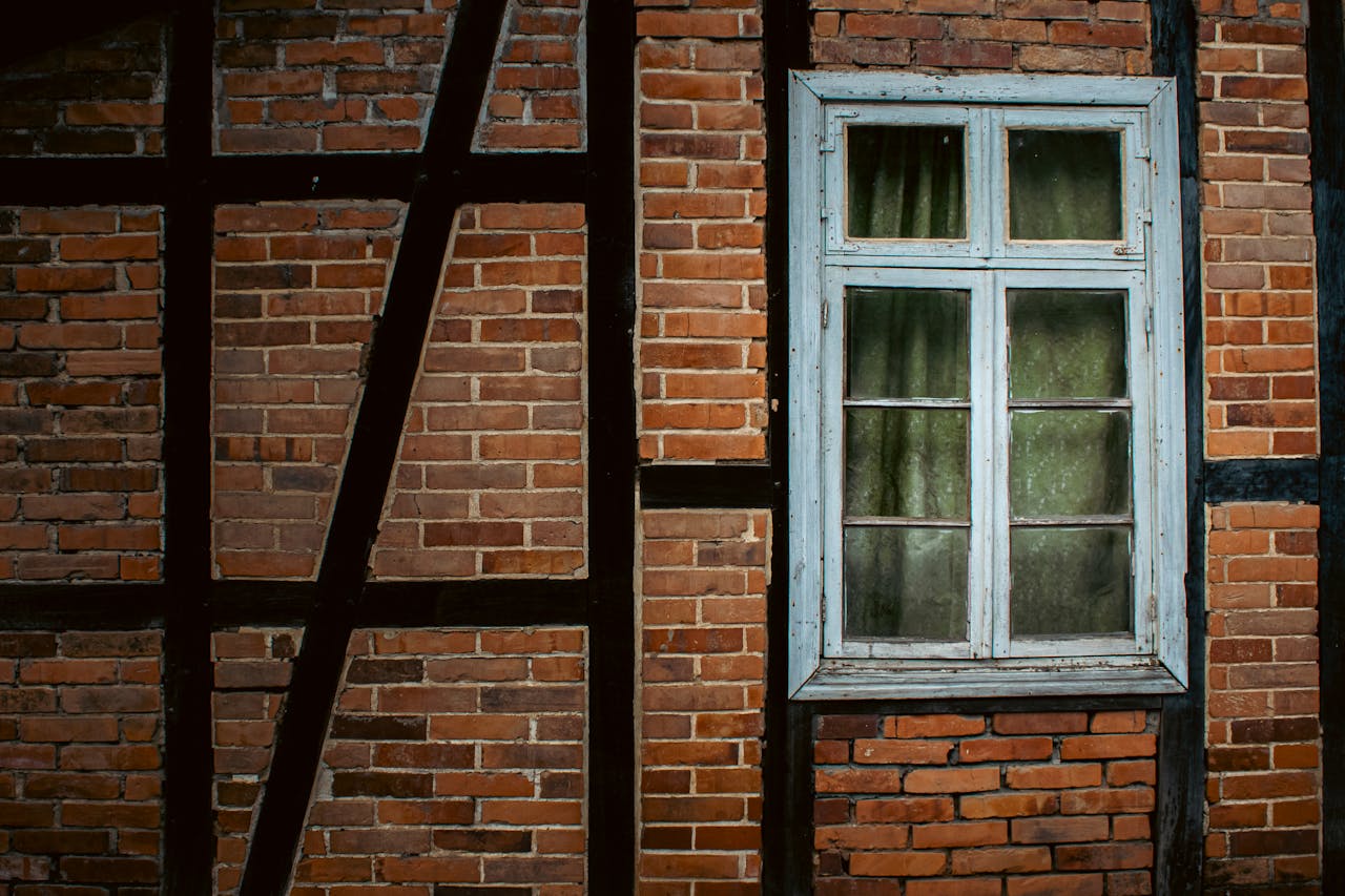 Fachwerk architecture in Santa Catarina, Brazil, showcasing a rustic brick wall with vintage wooden window frame.